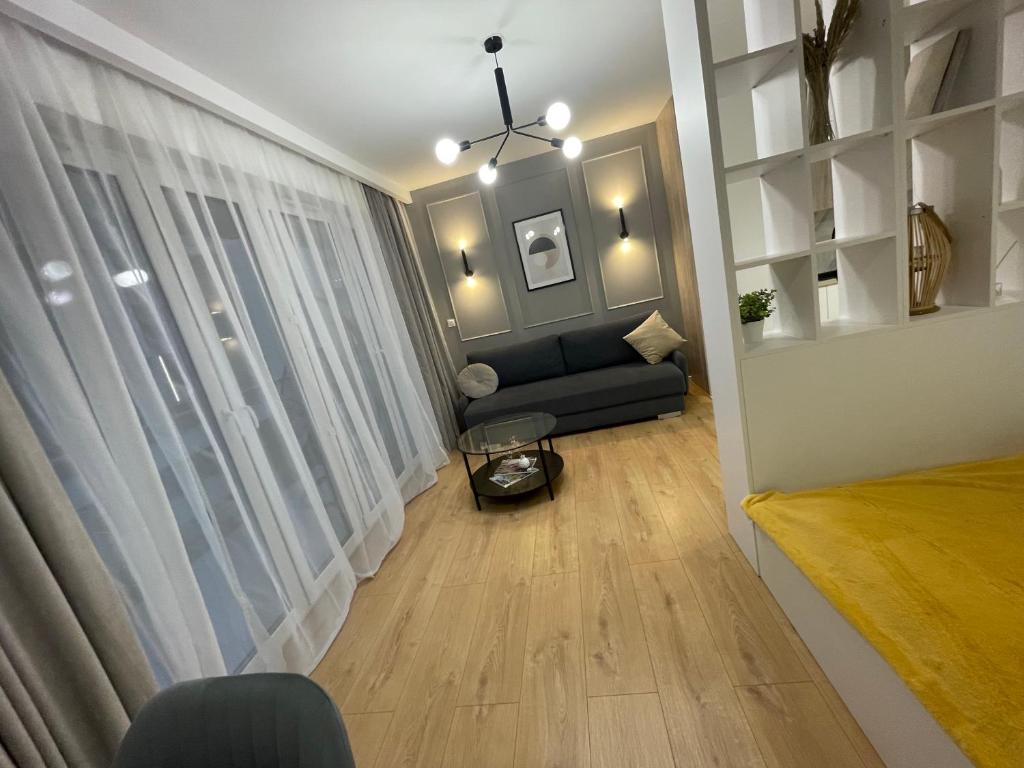 sala de estar con sofá y ventana en Rainbow Apartments Premium CENTRUM, en Kielce