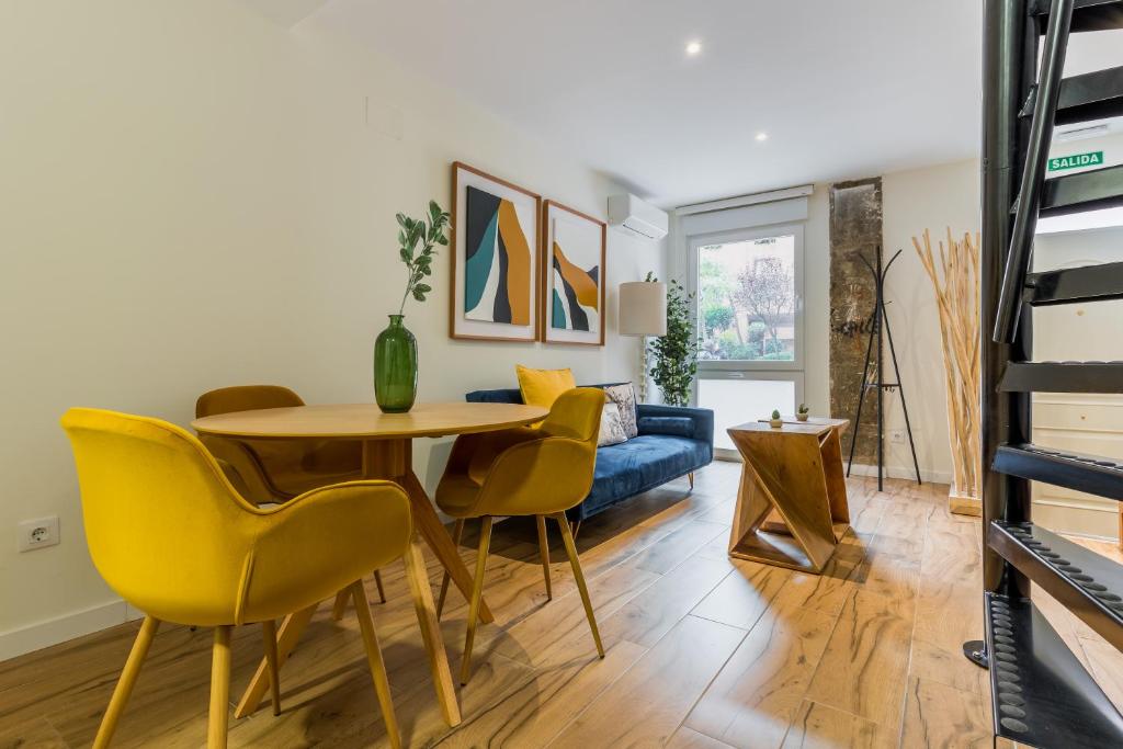 a living room with a table and yellow chairs at Bright and cozy- 1D 1B- Plaza Castilla in Madrid