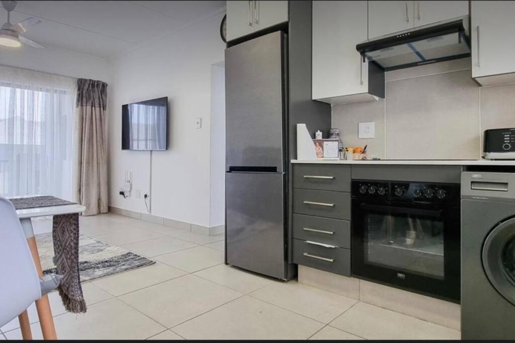 a kitchen with a stainless steel refrigerator and a dishwasher at Leisure apartment in Ballito
