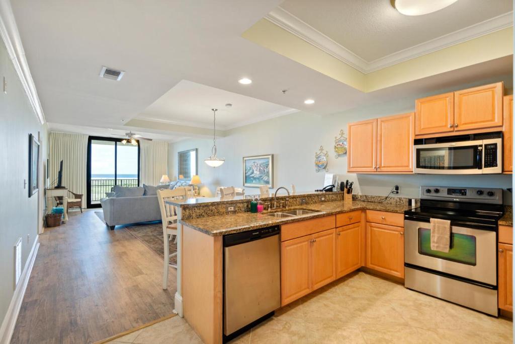 cocina con armarios de madera y sala de estar. en 204 Holiday Isle, en Dauphin Island