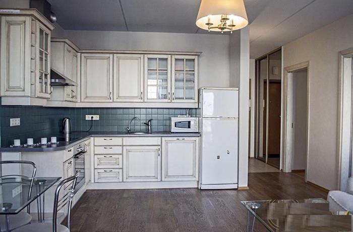 eine Küche mit weißen Schränken und einem weißen Kühlschrank in der Unterkunft Real appartment in Vilnius