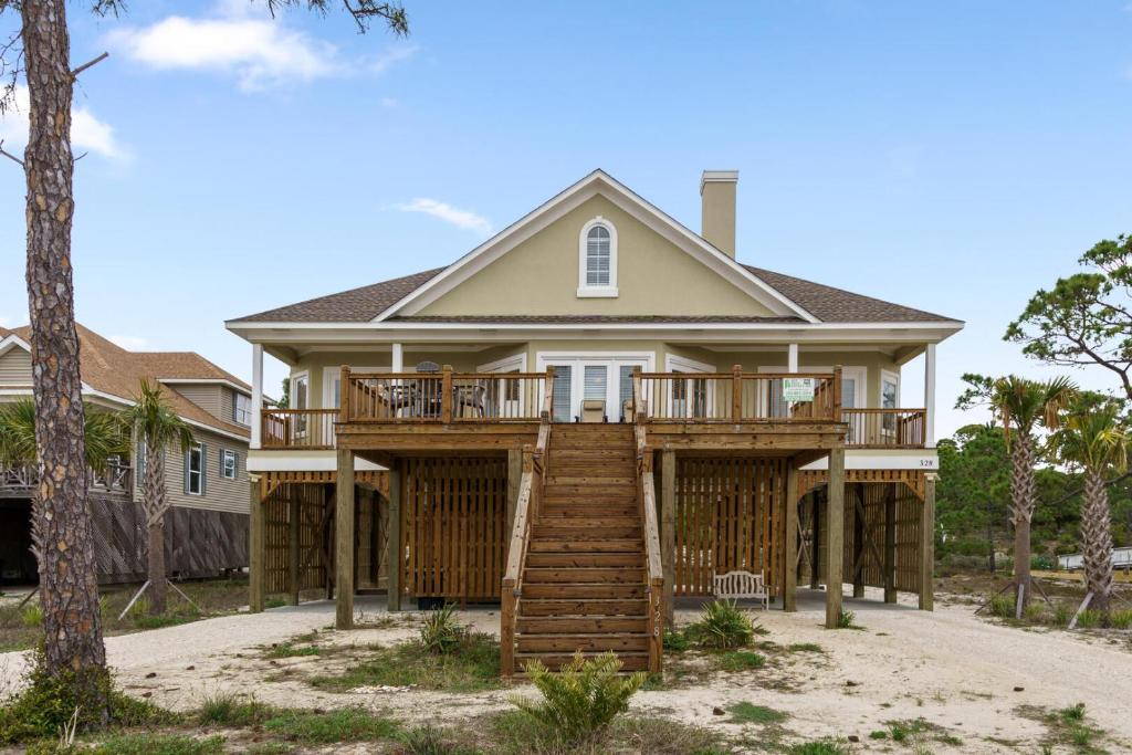a house with a wrap around porch with a deck at 025 The Sanderling in Dauphin Island