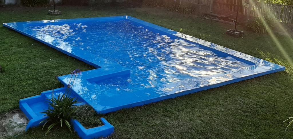 uma piscina azul na relva com um escorrega aquático em Quinta San Francisco 