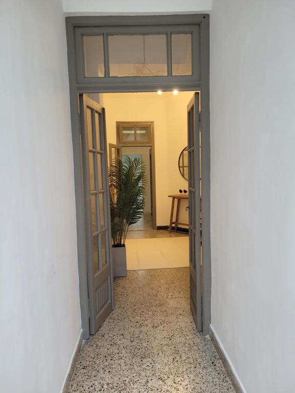 una puerta abierta que da a un pasillo con una planta en Casa Supremo, en Concepción del Uruguay