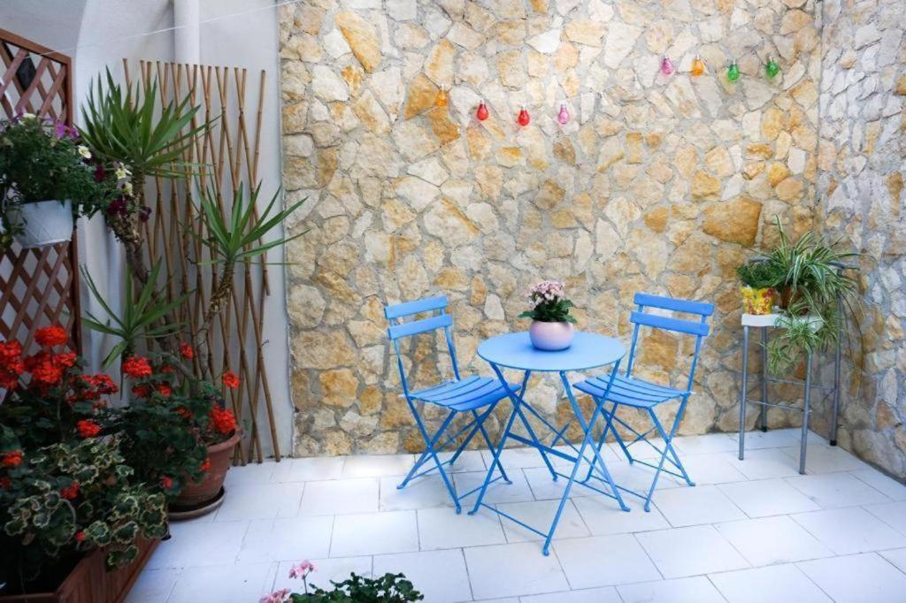 uma mesa e cadeiras num pátio com plantas em Blue Courtyard HOWME em Bari