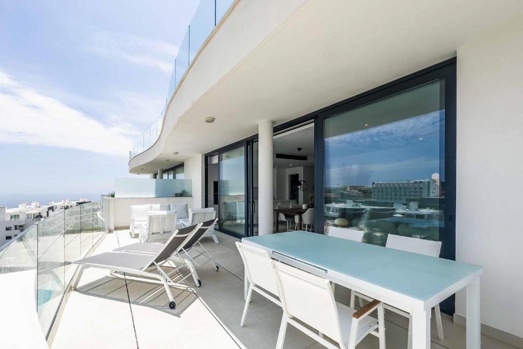 a balcony with a blue table and chairs on it at 96-brand new apartment, Fuengirola in Fuengirola