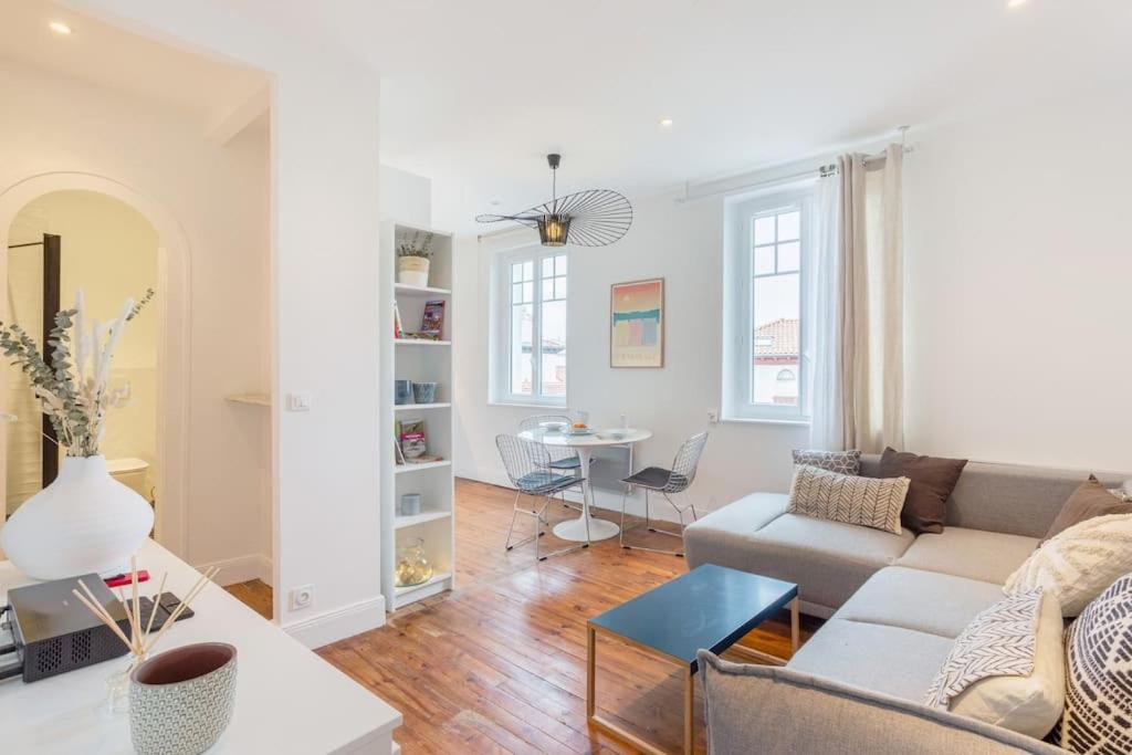 een woonkamer met een bank en een tafel bij Appartement rue Gambetta, plage à 2 min in Saint-Jean-de-Luz
