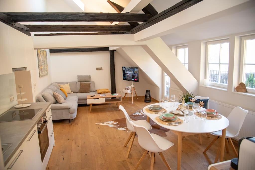 a kitchen and living room with a table and chairs at Penthouse mit Altstadtflair in Graz