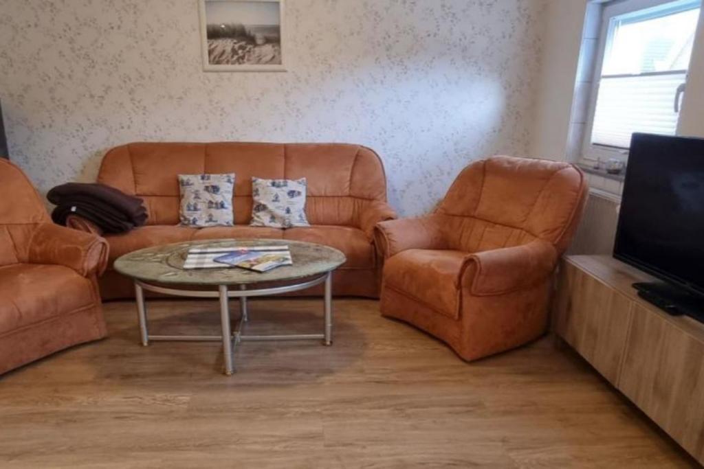 ein Wohnzimmer mit einem Sofa, 2 Stühlen und einem Tisch in der Unterkunft Fewo Voßeler in Büsum