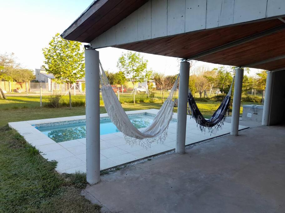 a porch with a hammock next to a pool at Casa Quinta Gualeguaychu in Gualeguaychú