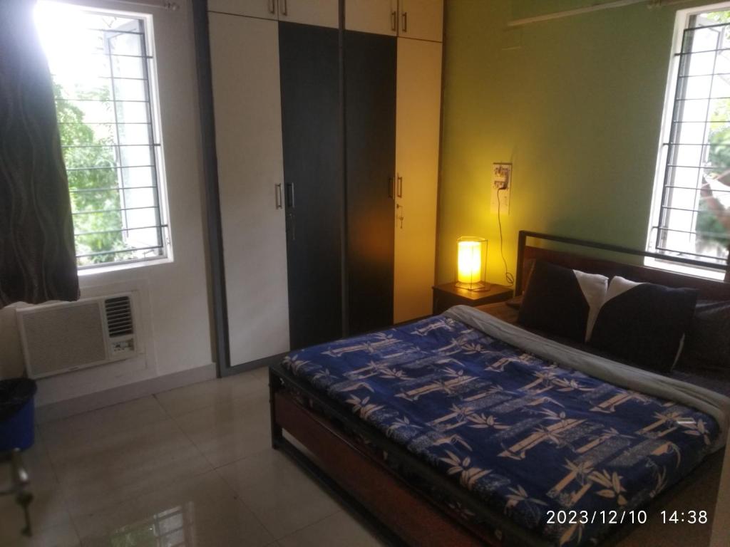 Royale Seaward Comfort Suites في تشيناي: غرفة نوم بسرير ونوافذ