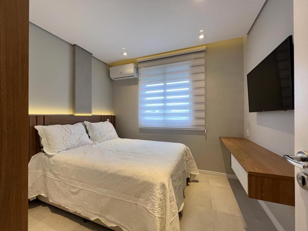 a bedroom with a bed and a flat screen tv at Lindo Apto Mobiliado próximo a praia em Santos in Santos