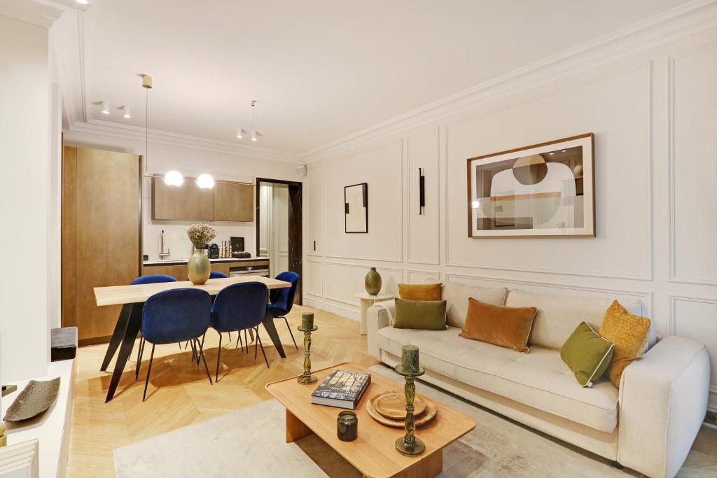 un soggiorno con divano e tavolo di TheLander - Champs Elysées Serviced Apartments a Parigi