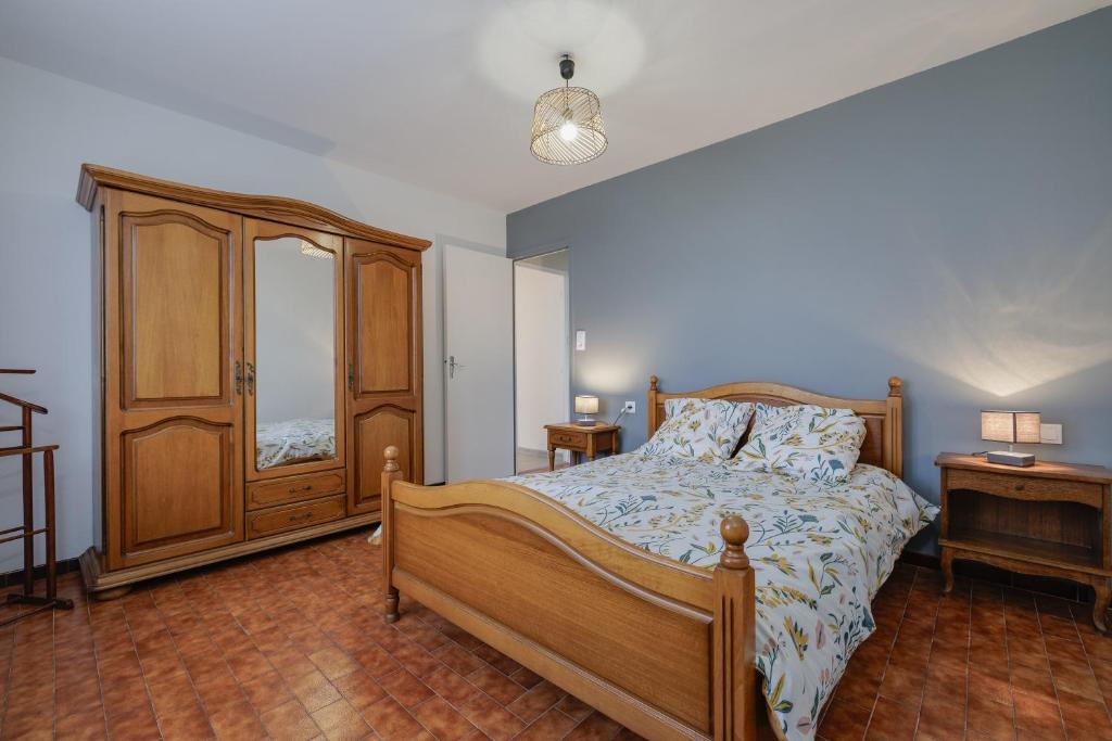 a bedroom with a bed and a wooden cabinet at Gite du maine in Langon