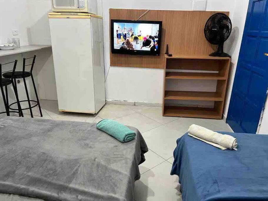 uma sala de estar com duas camas e uma televisão em Studio Aconchegante Ao lado Expo Center Norte SP em São Paulo