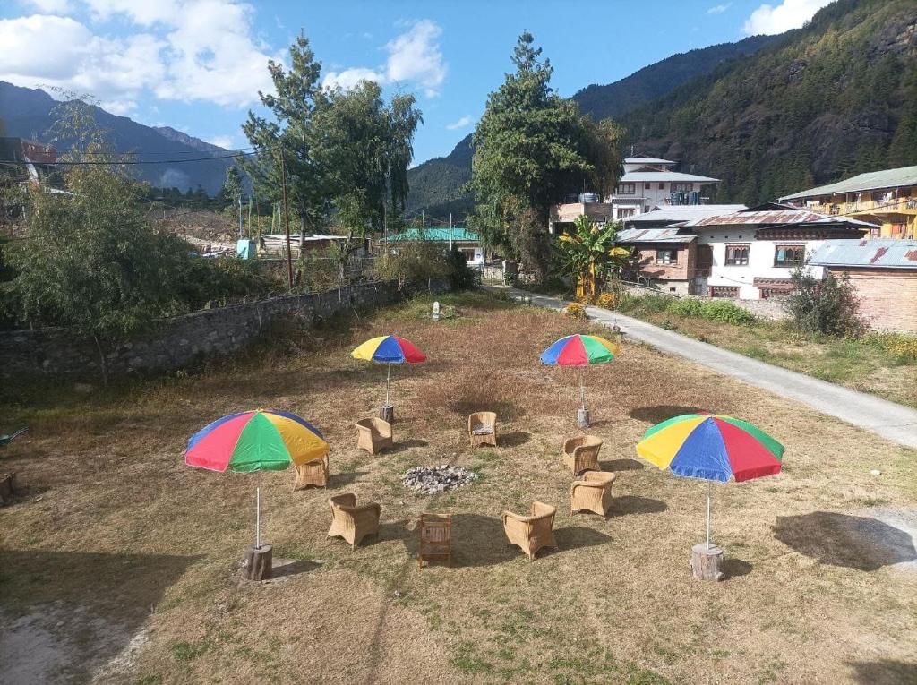 a group of umbrellas and chairs in a field at Zomsa home garden lounge in Paro