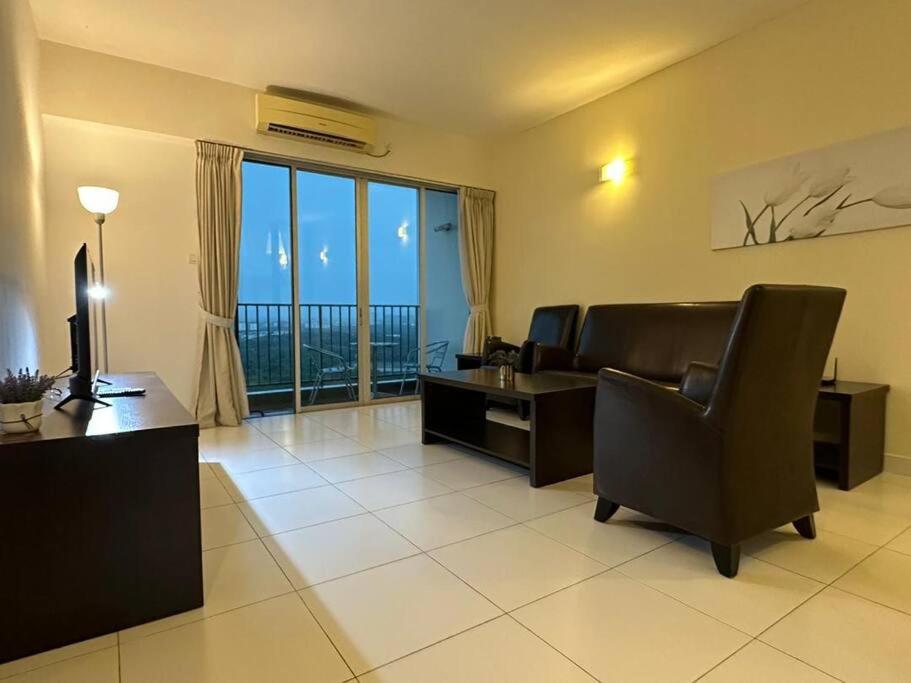 a living room with a couch and a desk and a television at Bayu Marina Resort 3 Bedroom in Johor Bahru