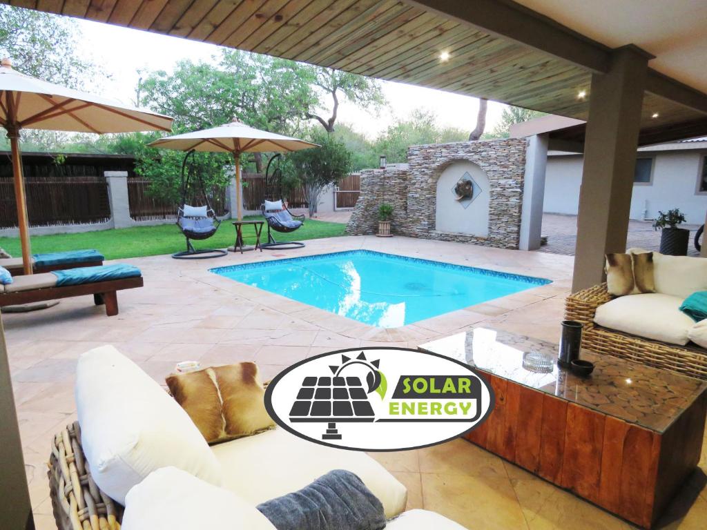 a swimming pool in a backyard with a patio furniture at Wild Dog Guest Lodge in Hoedspruit