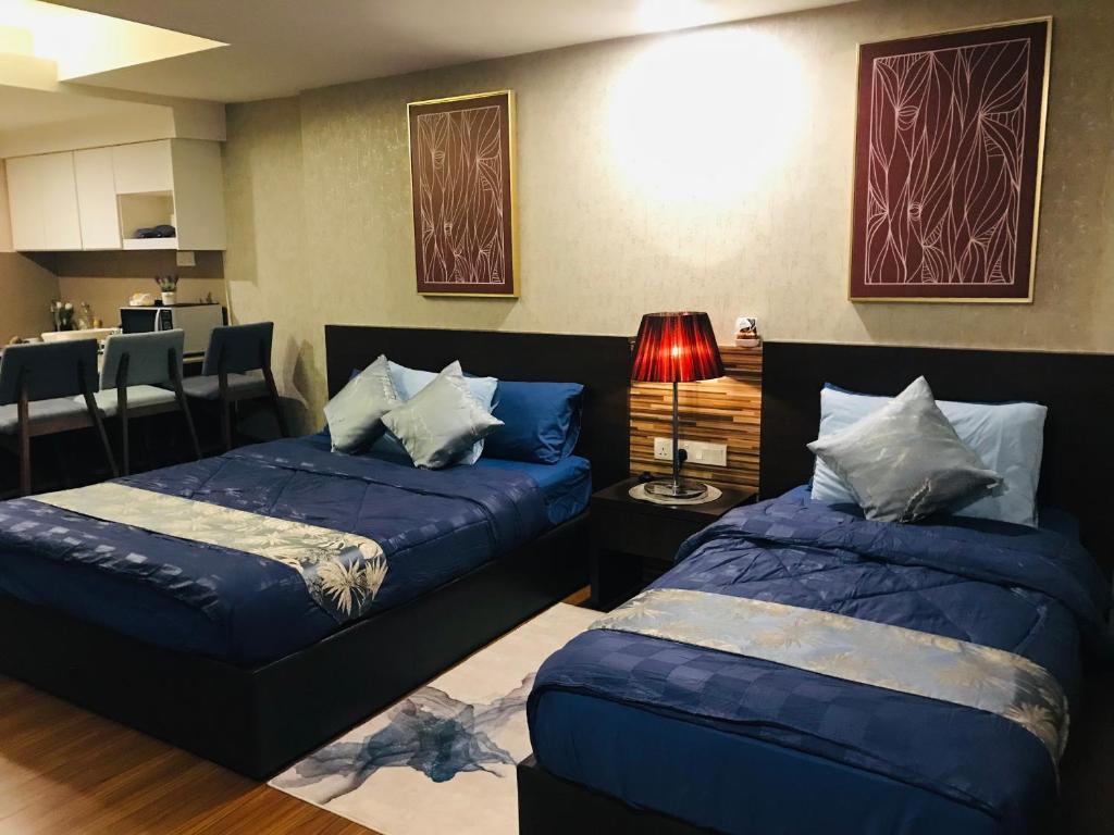 Cet appartement comprend une chambre avec deux lits et un salon. dans l'établissement FirIzzkey Studio, à Kota Bharu