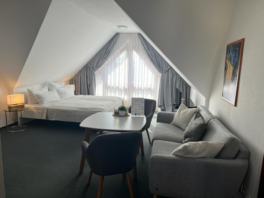 Cette chambre comprend un lit, un canapé et une table. dans l'établissement Pension am Markt, à Lübben
