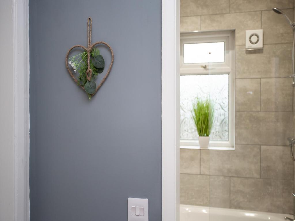 a bathroom with a heart hanging on the wall at Langley Park House, Durham in Langley Park