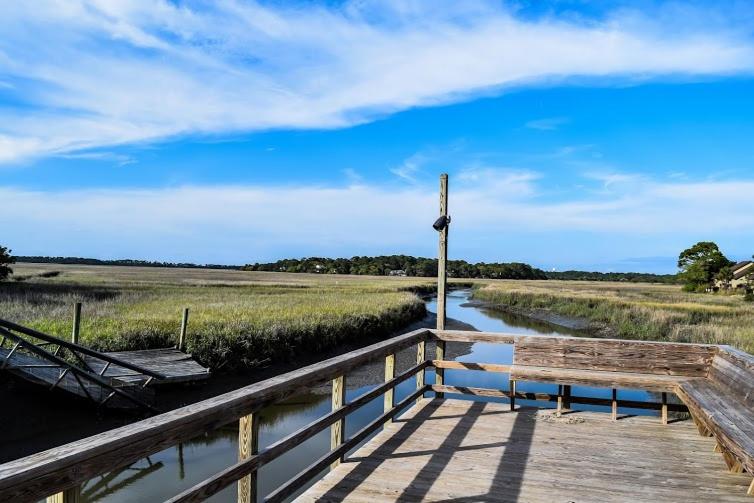 a wooden dock with a bench next to a river at Ocean Bliss Cottage! Beach Club Villa with Canal Views - Short walk to Beach in Fripp Island