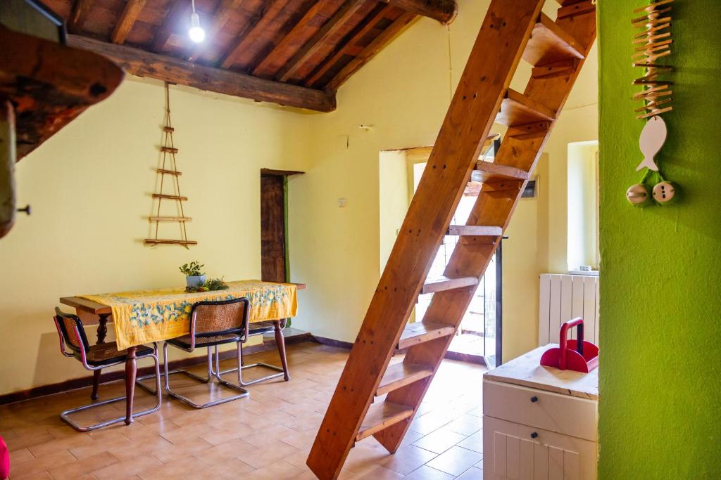 een eetkamer met een tafel en een houten ladder bij La Castellaccia in Campagnatico