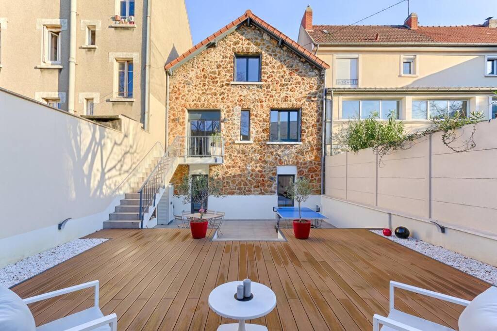 a balcony with a wooden floor and a building at Magnifique Villa Anatole France en plein coeur de Paris - 11P in Saint-Denis