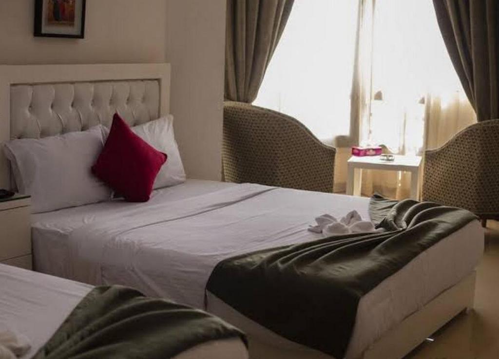 - une chambre avec un lit et un oreiller rouge dans l'établissement City inn Cairo hostel Caca, au Caire