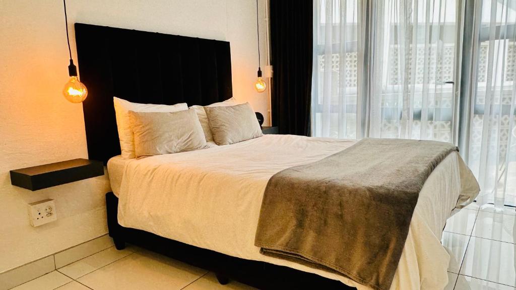 Un dormitorio con una cama grande con una ventana grande. en Industrial CHIC Apartment 113 - Luxury City Escape, Washing Machine & Fast WiFi, en Johannesburgo