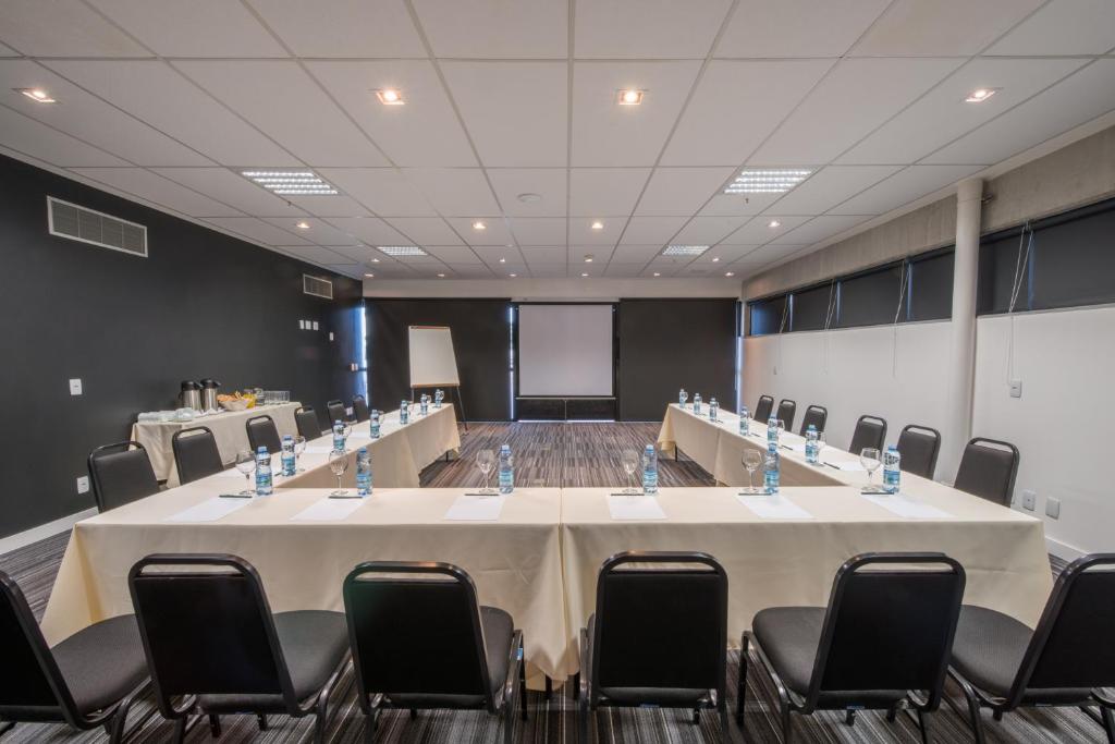 a conference room with a large table and chairs at Linx Galeão in Rio de Janeiro