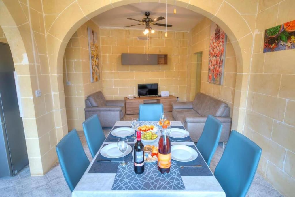 uma sala de jantar com uma mesa e cadeiras azuis em 36, Serina Court - Marsalforn, Gozo - Malta em Marsalforn
