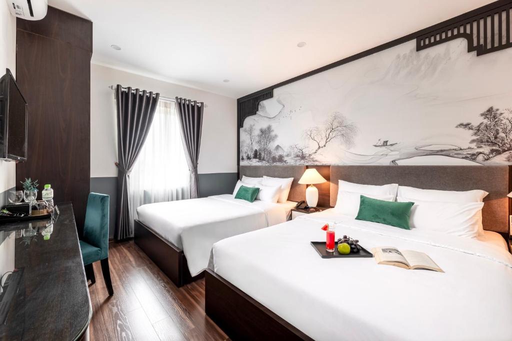 a hotel room with two beds and a desk at Hanoi Elpis Hotel & Spa in Hanoi