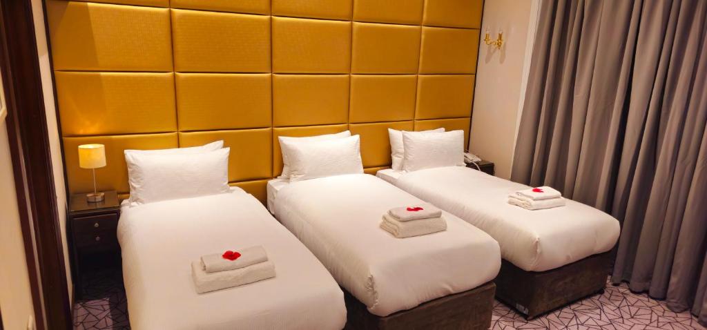 una habitación de hotel con 2 camas con corazones en Hyde Park International, en Londres