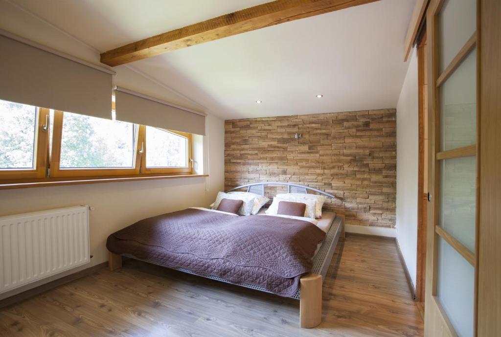 シュチルクにあるApartament Na Górskiejのレンガの壁とベッド(枕付)が備わるベッドルーム1室が備わります。