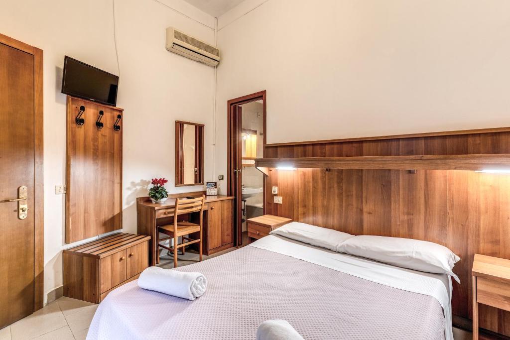 sypialnia z 2 łóżkami, biurkiem i umywalką w obiekcie Hotel Giada Roma w Rzymie