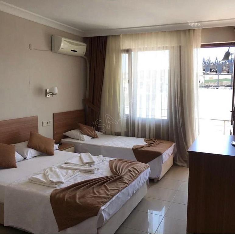 a hotel room with two beds and a window at Turan Hotel in Atakum