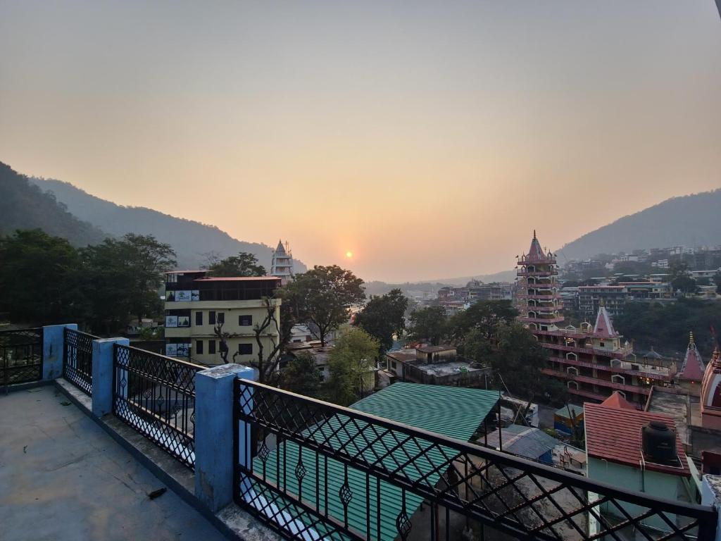 desde un balcón con vistas a la ciudad al atardecer en Karwaan Homestay, en Rishīkesh