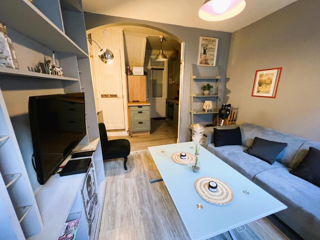 uma sala de estar com um sofá azul e uma mesa em Maison de pêcheurs Malvina em Le Tréport