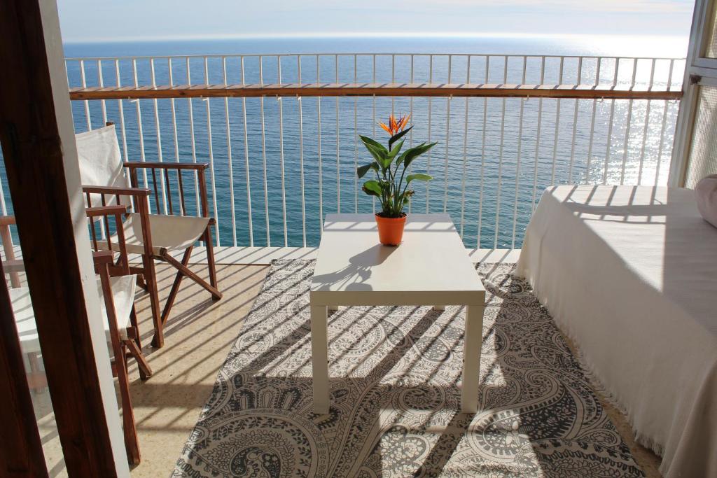 Un balcón con una mesa y una planta. en Apartamento Torre Alacant, en Alicante