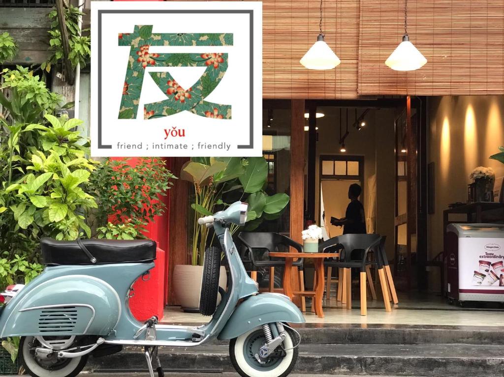 uma scooter estacionada em frente a um restaurante em Yu Cafe Hostel em Songkhla