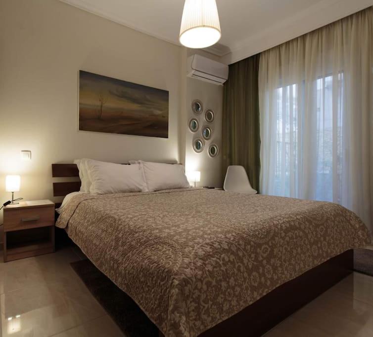 een slaapkamer met een groot bed en een raam bij Irida Equanimity and Cozy Apartment in Thessaloniki