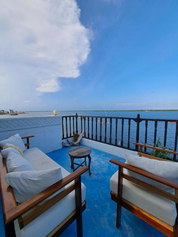 Un balcón con sofás y vistas al océano. en Pwani House - Lamu Seafront, en Lamu