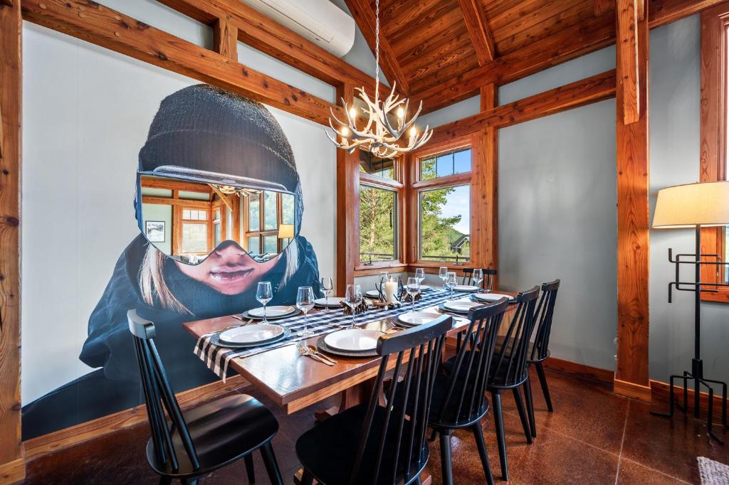a dining room with a large painting on the wall at Walk to Village! Stunning timber chalet! Hot-Tub, Bonfire & more! in Ellicottville