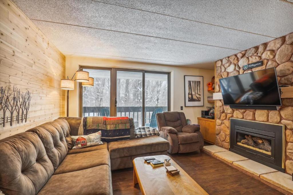 a living room with a couch and a fireplace at Pinnacle B14 in Killington