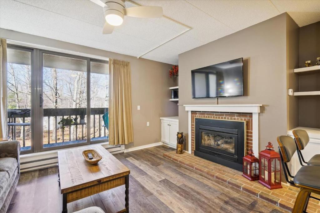 a living room with a fireplace and a tv at Pinnacle B12 in Killington