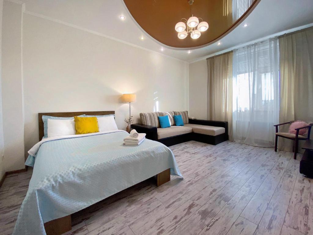 um quarto com uma cama grande e um sofá em Чарівна, простора квартира в 2хв від МВЦ, Лівобережна em Kiev