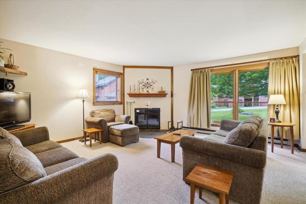 a living room with two couches and a fireplace at Trail Creek 43 in Killington