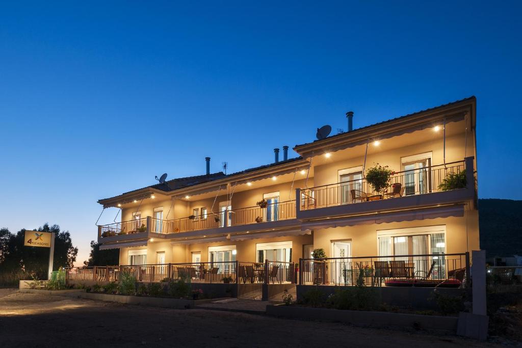 um grande edifício com uma fachada iluminada à noite em 4 Seasons Villas em Plataria