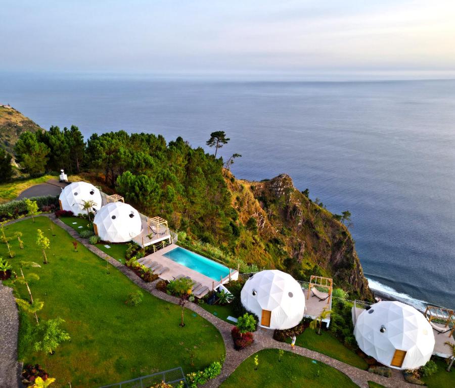 an aerial view of luxury tents on a hill next to the ocean at Vi Naturae Glamping in Fajã da Ovelha